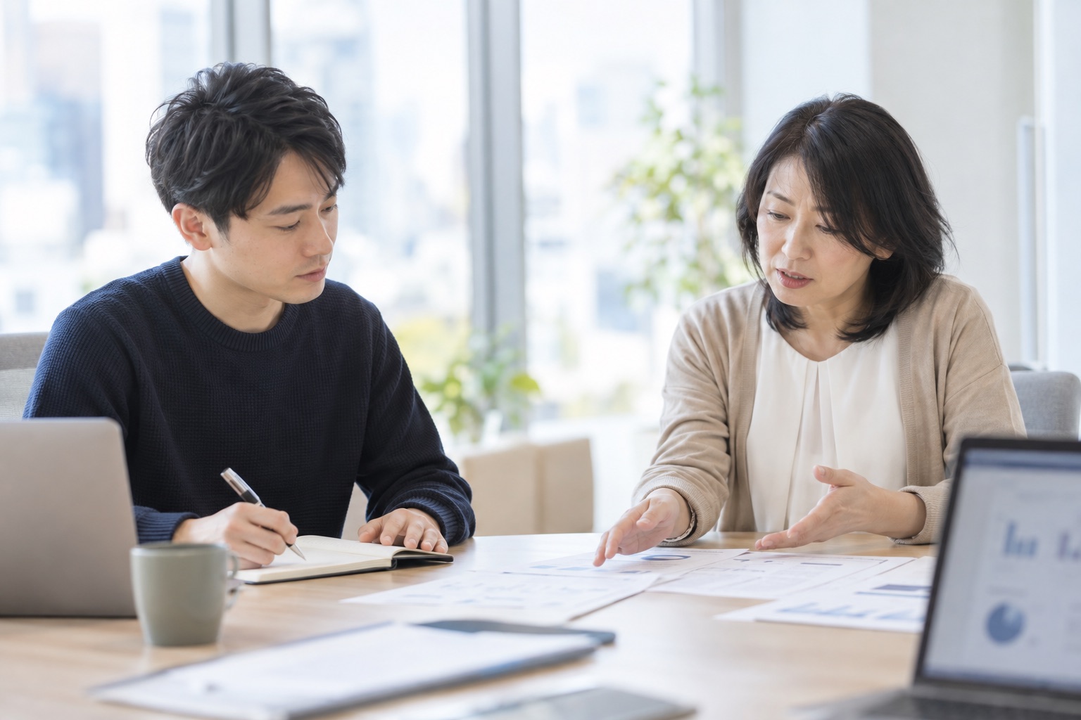 会議室でお客様から業務の流れを聞き取る担当者