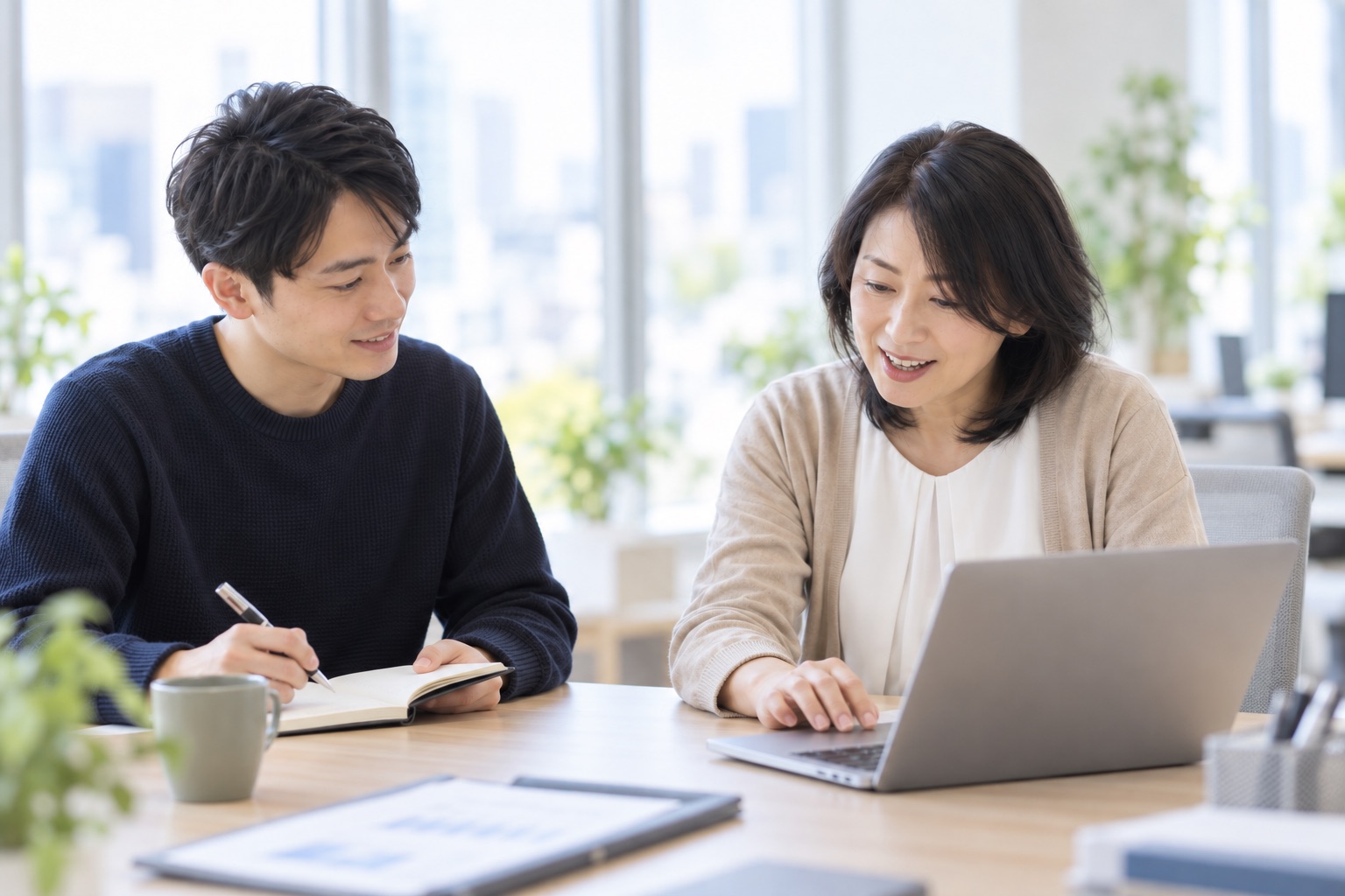 開発中のシステムをお客様が試し、担当者が隣で見守る様子